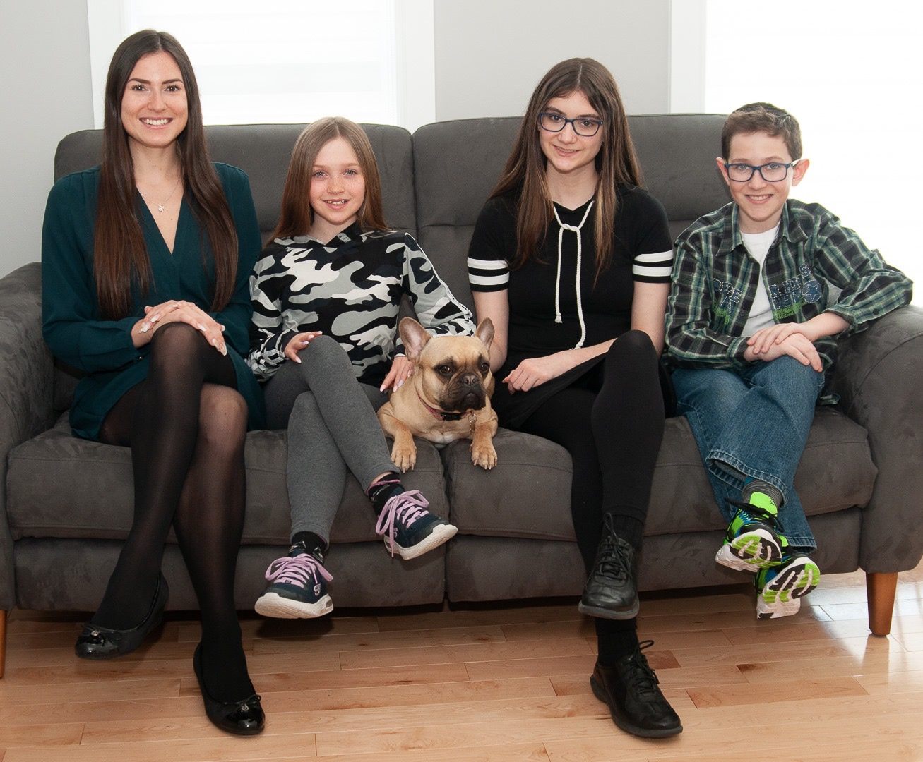 Maude Bernier, fondatrice et orthopédagogue de Tandemo, entourée d’enfants et de leur chien sur un divan